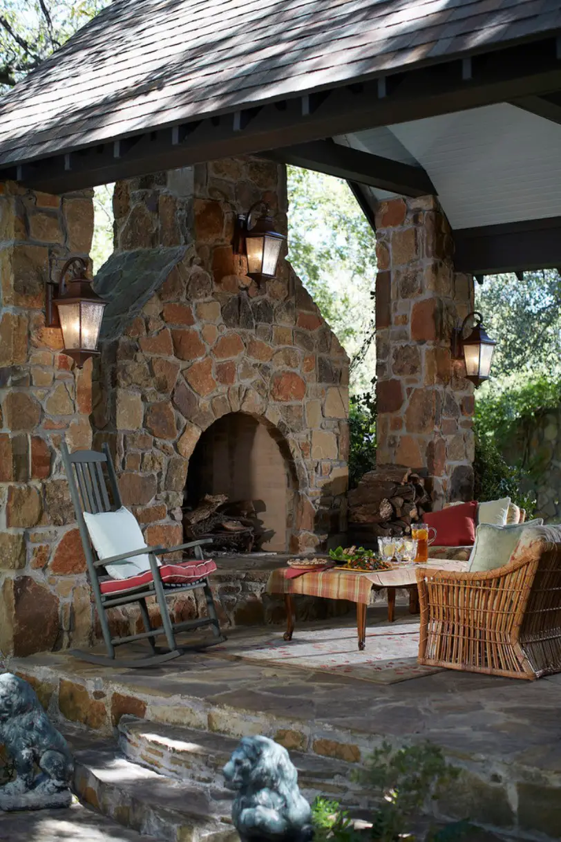 Rustic Patio With A Stone Fireplace And Pillars